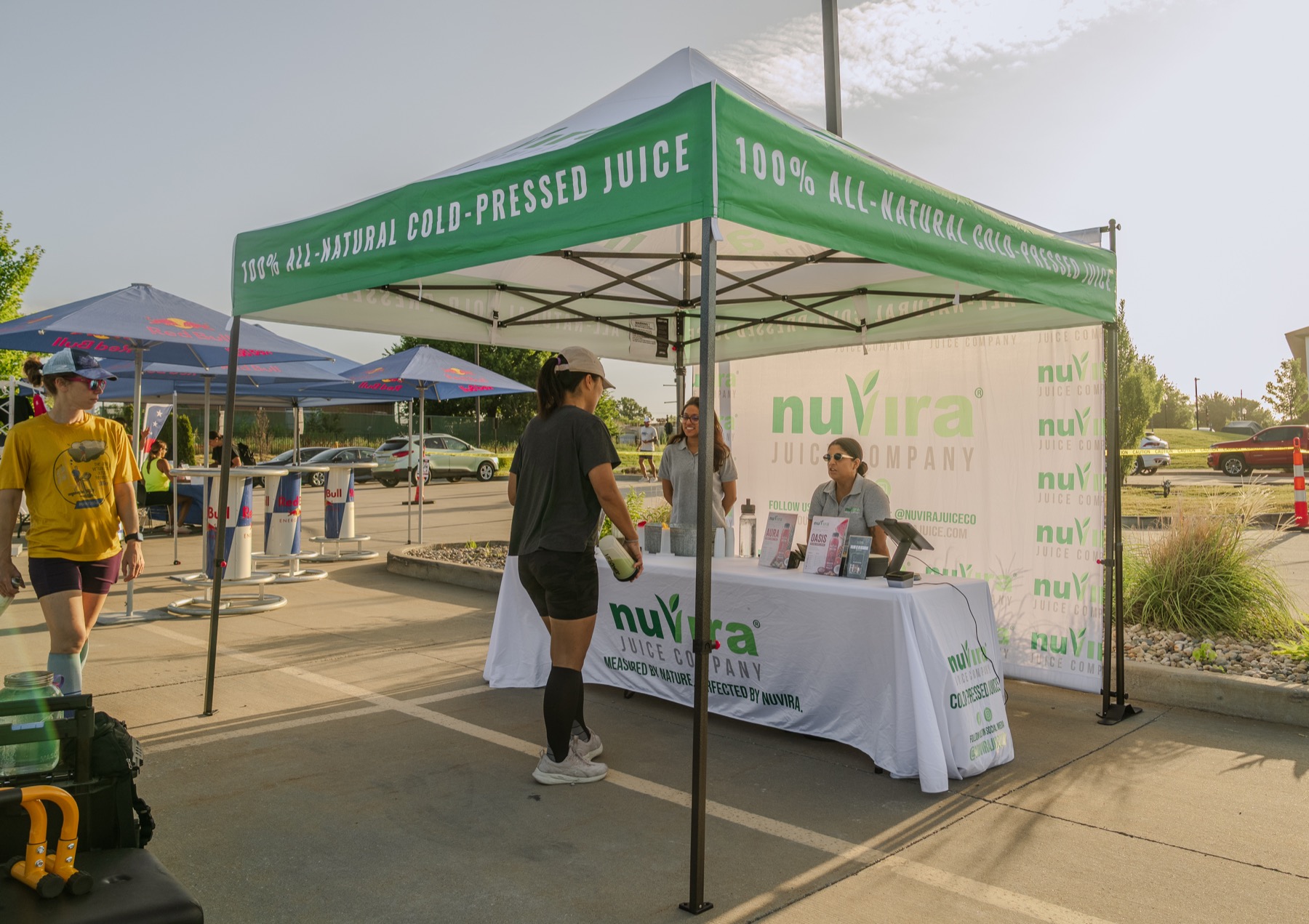 The NuVira team sharing cold-pressed juice with guests at a local outdoor event